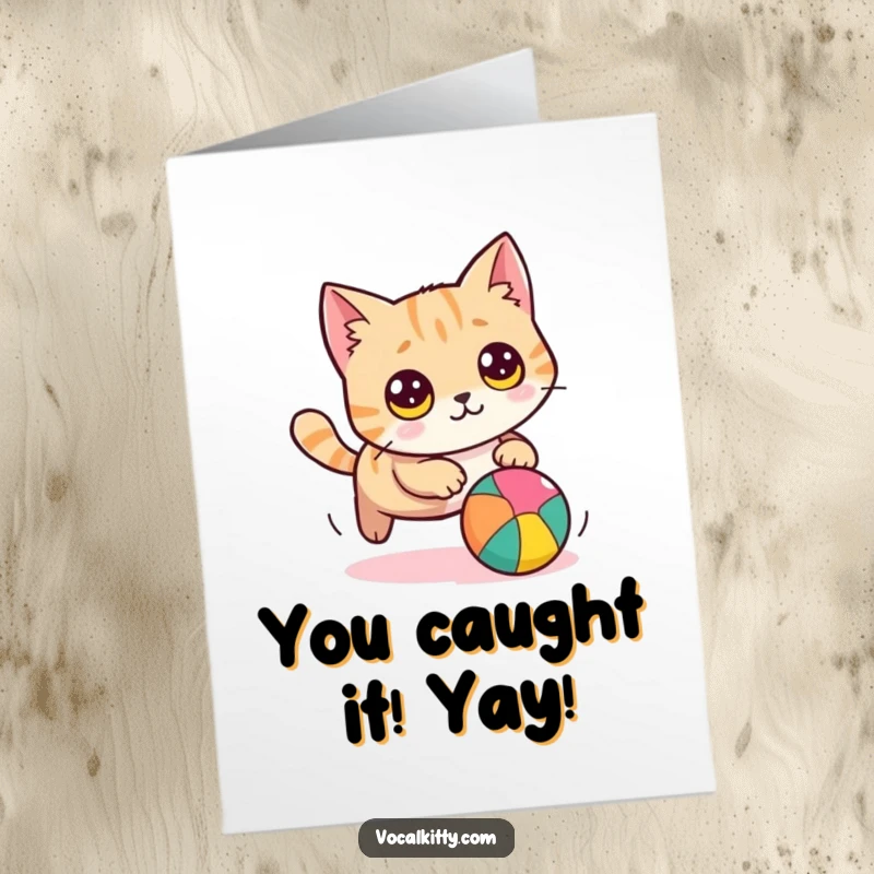 Funny Free Printable Congratulations Card showing a playful, round cat with big eyes chasing a colorful ball with pure excitement.