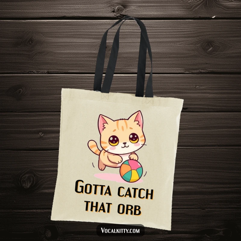 Funny cat tote bag illustration of a round cat with wide eyes, playfully chasing a brightly colored ball, useful and humorous.